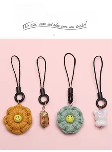 Detailed set of floral and bear phone charms with black rings on pink background
