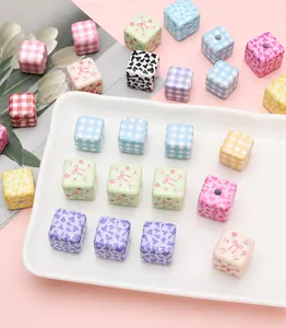 Close-up of DIY acrylic cube beads with floral and plaid prints for handmade jewelry