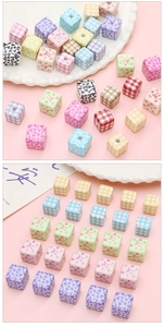 Macro detail of acrylic floral and bow print cube beads for DIY jewelry making