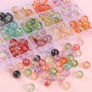 DIY glass beads set with gold foil and ink smudge patterns in a plastic storage box