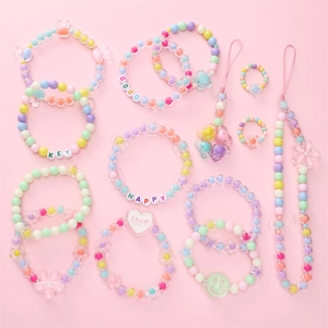 Détail de bijoux DIY pastel avec perles alphabet et pendentifs fleurs colorées
