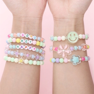 Ensemble de bracelets en perles macaron avec lettres et breloques sur fond rose