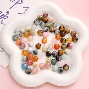 Macro display of 10mm faceted and polished natural stone beads in a white flower dish