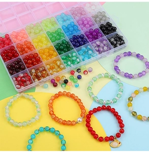 Detailed view of 24-compartment storage box with colorful 8mm glass beads and finished bracelets