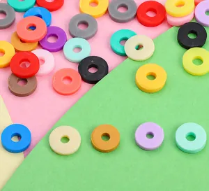 Flache Darstellung bunter Polymerton-Perlen für DIY-Armbänder auf geometrischem Papier