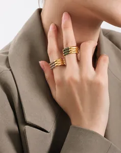 Detalle de los anillos de triple capa bañados en oro de 18k con cristales blancos y verdes