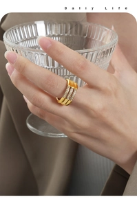 Detalle del anillo de oro de 18 quilates con tres filas de cristales y diseño ondulado