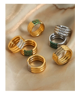 Detalle de anillos multicapa de oro y plata con cristaux sobre seda champán