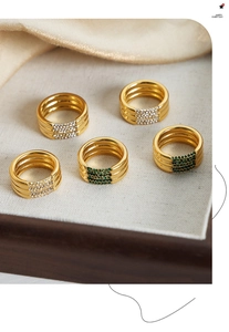 Detalle macro de anillos vintage en oro de 18k con cristales checos blancos y esmeralda