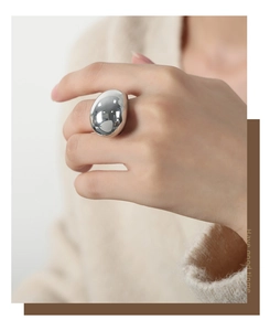 Close-up of a silver oversized chunky pebble ring on finger with high-polish mirror finish