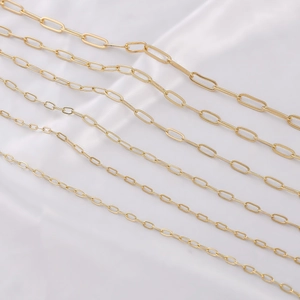 Multiple strands of 14K gold filled paperclip chains on white silk background
