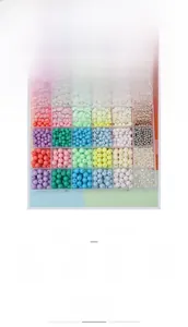 Macro detail of a 24-grid DIY jewelry kit with colorful acrylic beads for crafting
