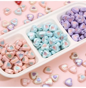 Macro detail of acrylic heart beads with iridescent pearl finish for DIY jewelry crafts