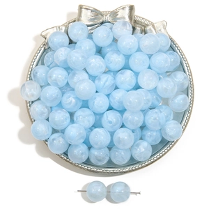 Light blue marble acrylic beads with smoky white patterns on a silver tray