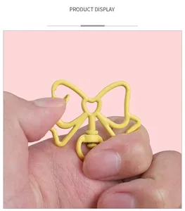 Détail du porte-clés nœud en métal jaune avec cœur ajouré et fermoir pivotant à 360 degrés