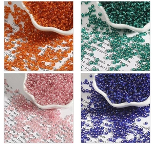 Detail of 450g high-gloss translucent glass seed beads in four vibrant colors for DIY crafts