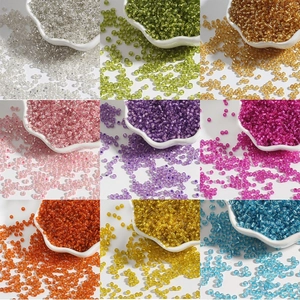 Assorted 9-color glass seed beads in floral porcelain bowls for DIY jewelry making crafts