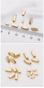 Macro detail of 14K gold plated rectangular and oval spacer beads for DIY jewelry making