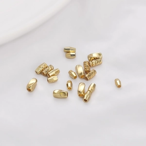 14K gold plated textured spacer beads for DIY jewelry making on white silk background