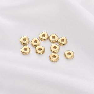 Polished 14K gold plated triangular spacer beads for DIY jewelry making on white silk