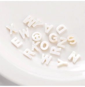 Macro shot of white freshwater shell letter beads for DIY jewelry and handmade crafts