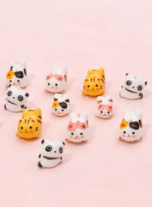 Detailed view of hand-painted ceramic cat and panda beads for DIY jewelry making