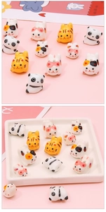 Detailed view of hand-painted ceramic cat and panda beads with holes for DIY jewelry