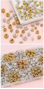Macro detail of gold and silver DIY jewelry beads and spacers in a grid organizer box