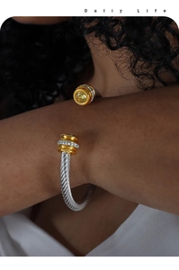 Détail du bracelet torsadé avec embouts dorés et pierres de zircone jaune vif