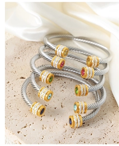Détail de joncs torsadés empilables avec zircons colorés et finitions en or 18 carats