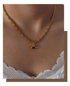 Macro view of gold rope chain necklace featuring a rectangular black stone pendant