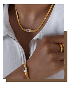 Nahaufnahme des Goldschmuck-Sets mit Schlangenkette, ovalem Stein und strukturiertem Ring