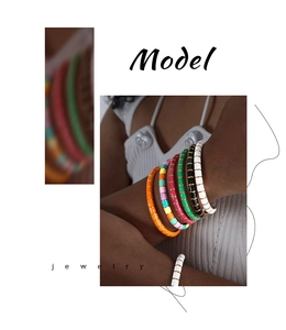 Buntes Macaron-Armband mit goldenen Trennelementen am Handgelenk des Models