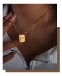 Close-up of golden Cuban link necklace with rectangle letter P pendant on model