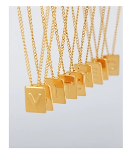 Close-up of gold plated square pendant necklaces with embossed letters on tarnish free steel