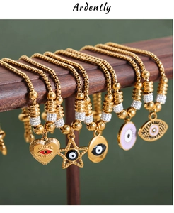 Detail von 18k vergoldeten Box-Armbändern mit Evil-Eye-Anhängern und verstellbarem Verschluss
