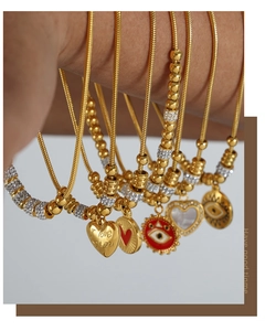 Detail der goldenen Schlangenkette mit Herzanhängern und Evil Eye Anhängern