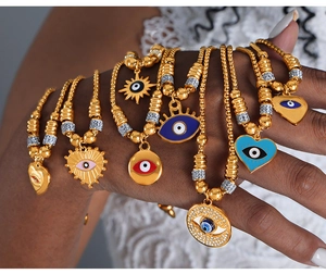 Detailaufnahme von 18K vergoldeten Evil-Eye-Armbändern mit Emaille-Anhängern und Zirkonien