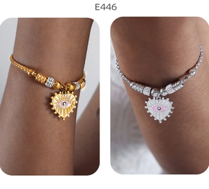 Detail von 18K Gold- und Silberherzarmbändern mit bösem Blick auf dem Handgelenk