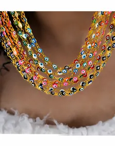 Detail of layered gold-plated titanium necklaces with colorful enamel evil eye beads
