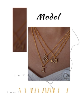 Detailed view of layered gold zodiac necklaces with sparkling rhinestone charms