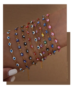Detail of colorful Evil Eye charm bracelets in nine enamel colors on a model's wrist