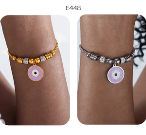 Makro-Detail von 18K Gold- und Silberperlenarmbändern mit Evil Eye Emaille-Anhänger