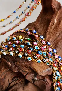 Detailed close-up of colorful Evil Eye gold plated steel beads on a wooden display