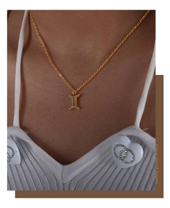 Close-up of Gemini constellation pendant necklace with sparkling diamonds on gold chain