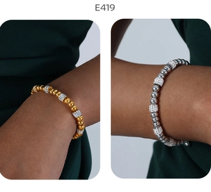 Detail von gold- und silbernen Perlenarmbändern mit funkelnden Strass-Zylinderelementen