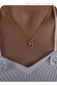 Close-up of a gold Taurus zodiac pendant with pavé set crystals on a delicate chain