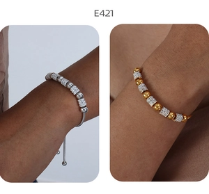 Detail von gold- und silbernen Perlenarmbändern mit funkelnden Strasssteinen am Handgelenk