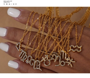 Macro detail of zodiac constellation necklaces with sparkling rhinestones in gold finish