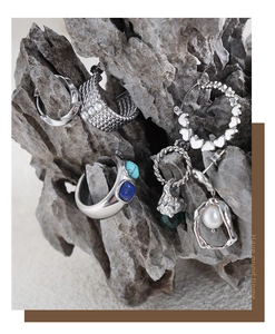 Détail de boucles d'oreilles argentées avec pierres turquoise et perles sur un rocher gris